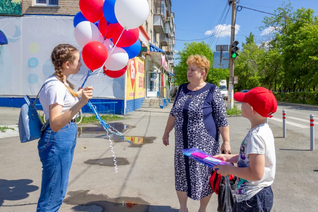 Коркинцев поздравляют с Днём России, вручая ленты, флажки и шары